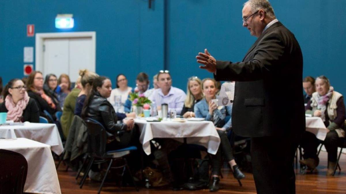 A confident small business owner leading a team meeting, symbolising strong leadership qualities and ethical decision-making in business.